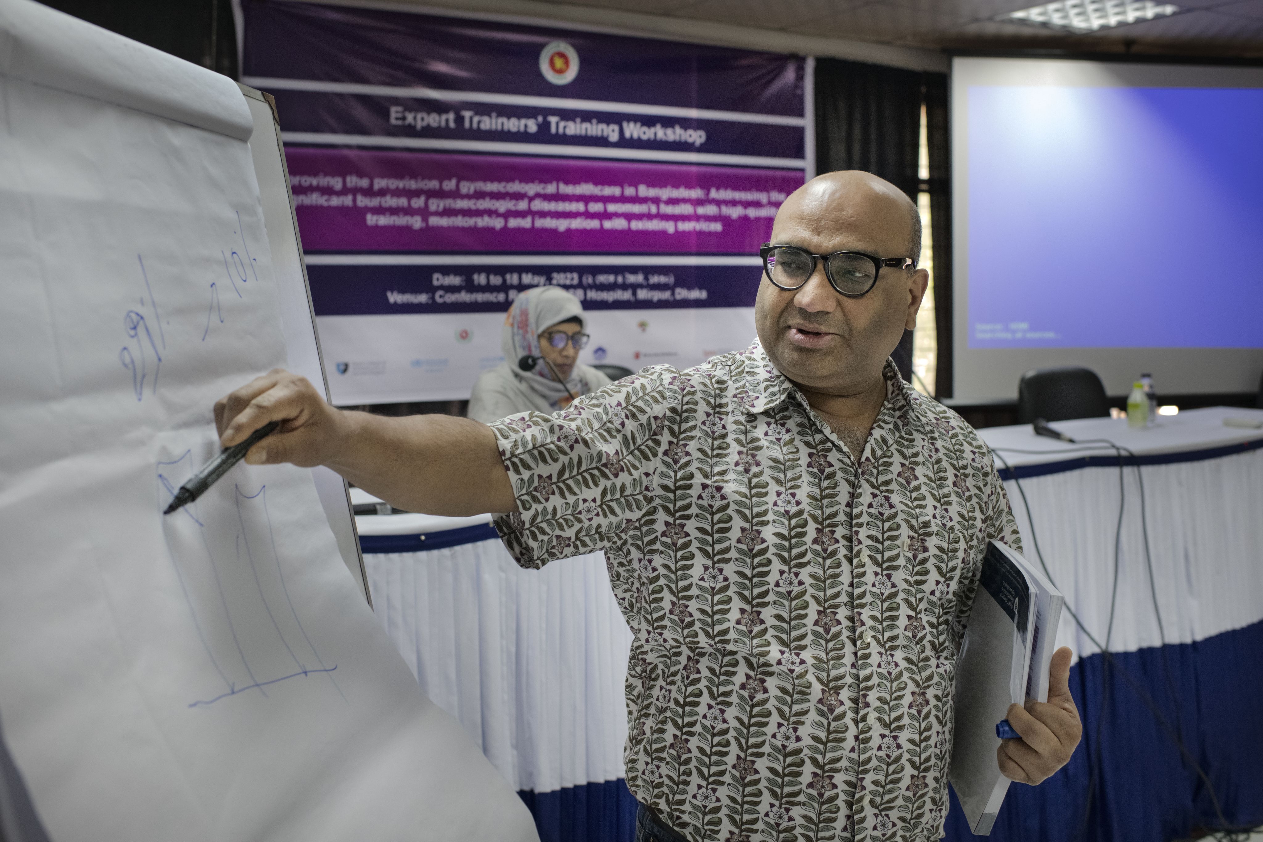 Dr Santanu Achyara, UK Clinical Lead on the Gynaecological Health Matters programme, teaching a session and pointing to a whiteboard