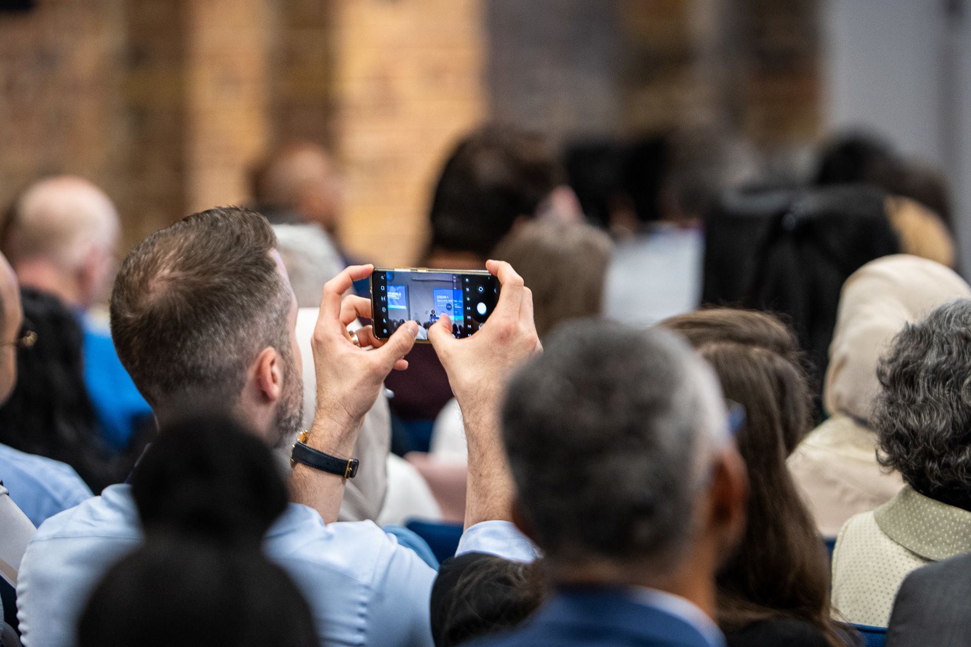An audience member taking a photo on their smartphone during a session at RCOG World Congress 2023.