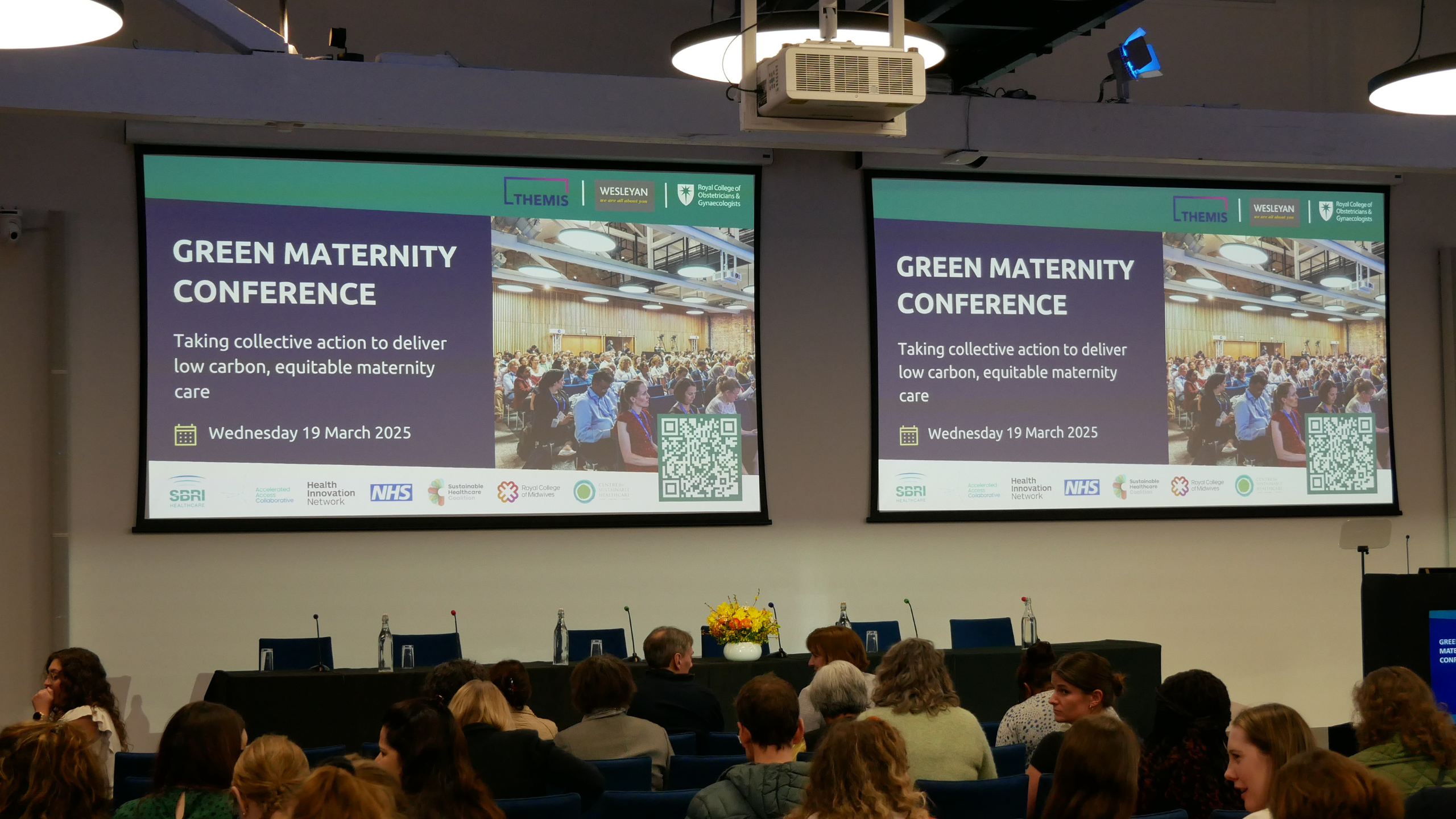 A photo of the stage and screens at the Green Maternity Conference