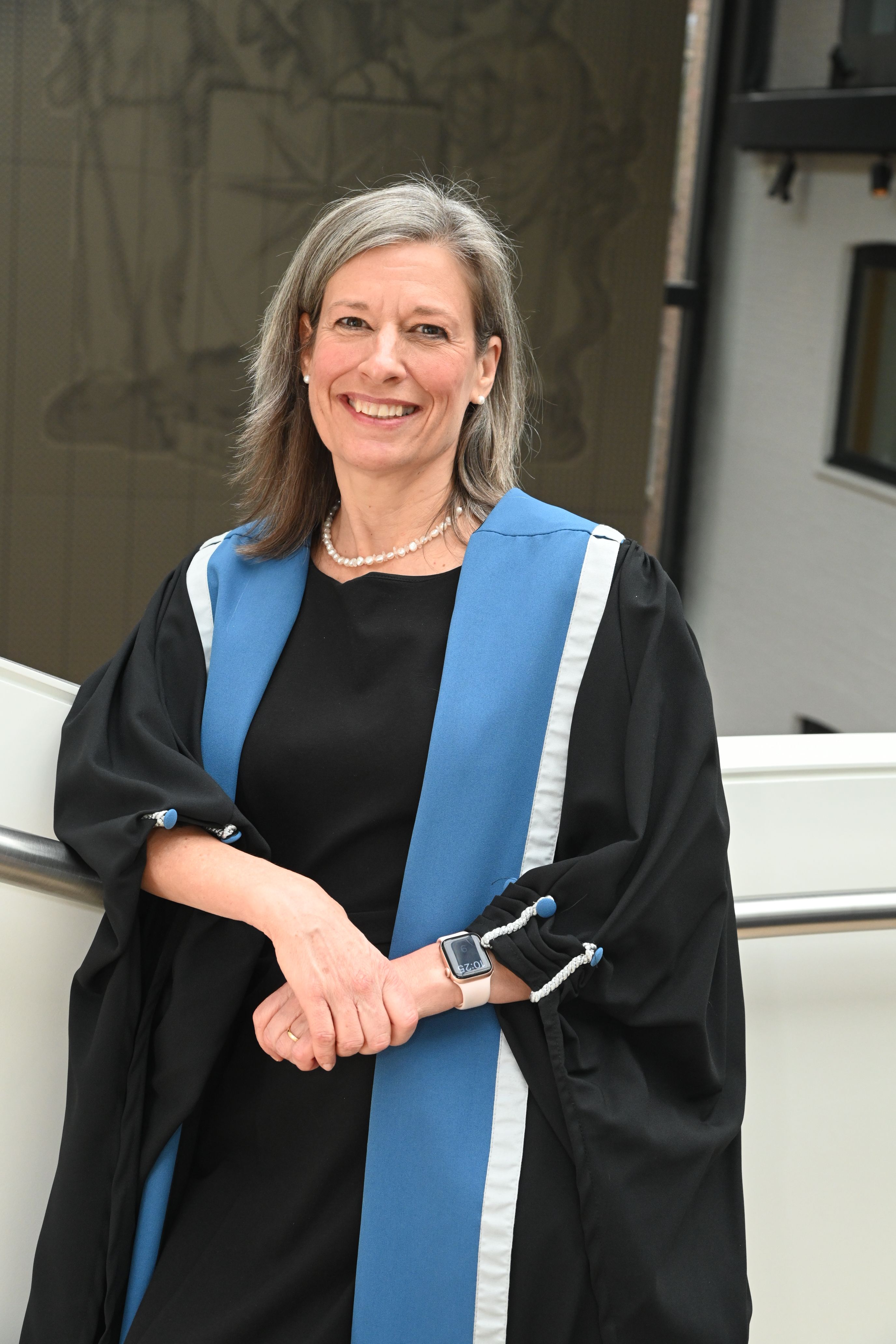 A photo of Vice President Laura Hipple in her College gowns, smiling at the camera