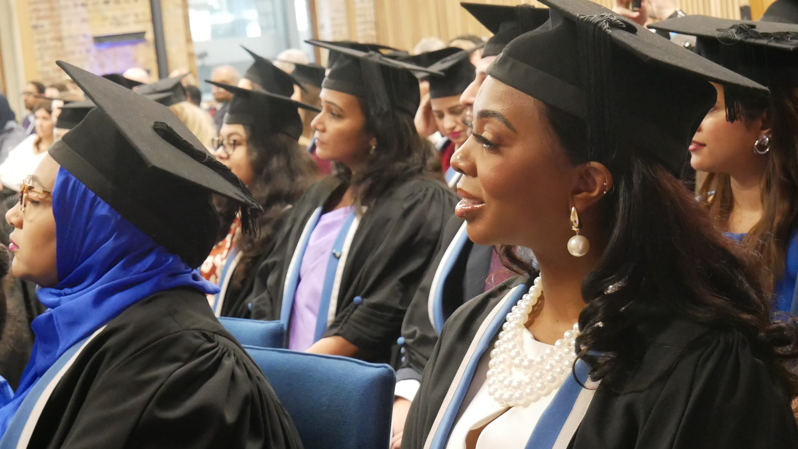 A group of RCOG members in gowns and mortarboards at an admission ceremony
